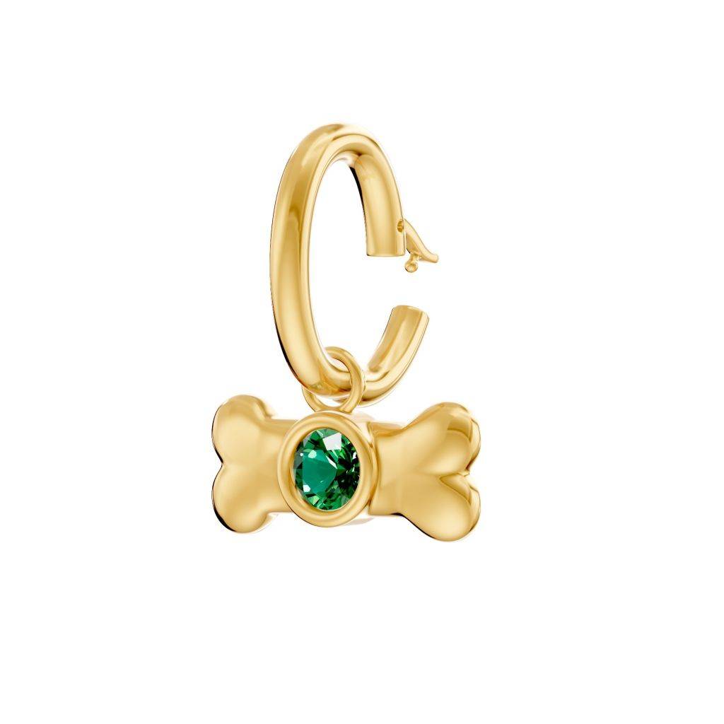 Illustration of a gold dog bone charm with a green jewel attached to a gold hoop.