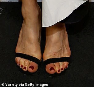 It is a thin 14kt gold toe ring which is worn on the third toe on her left foot