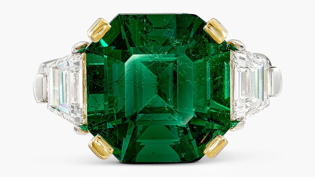 A ring with a step-cut, 7.90-carat Colombian emerald, flanked by trapeze-shaped, D-color diamonds weighing 0.56 and 0.53 carats at Sotheby's image