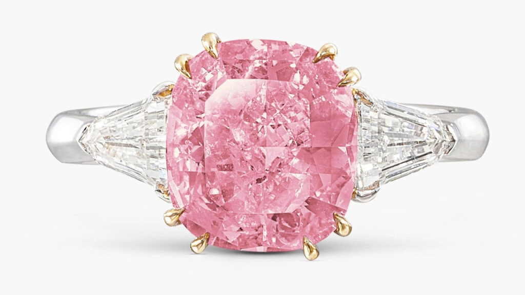 A ring with a cushion-shaped, 2.86-carat, fancy-vivid-purplish-pink, I2-clarity diamond flanked by two shield-shaped diamonds at Sotheby's image